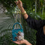 Feather saga evil eye mini bag in emerald green with feather embellishments